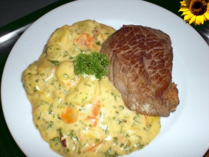 Pork medallions with potato and carrot in a cream sauce