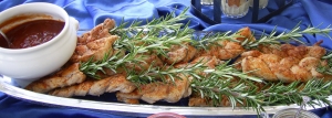 Pork tenderloin on rosemary skewer with pigtails hot sauce