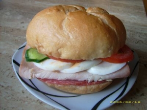 Kaiser roll with turkey salami egg tomato and cucumber