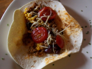 Wraps with minced meat corn beans tomatoes and cheese